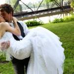 Bride and groom kissing in garden.