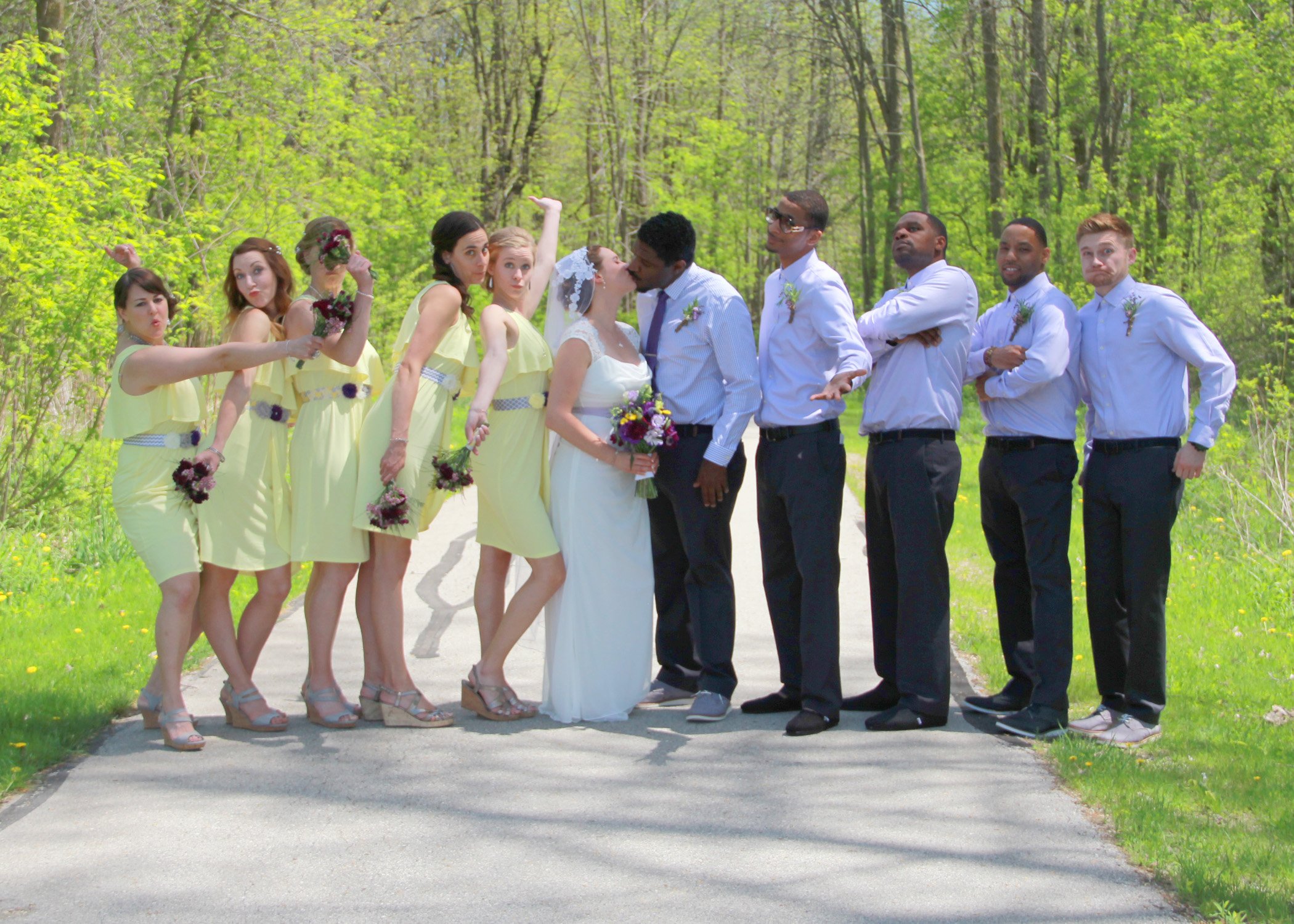 Wedding party posing outdoors on a sunny day.