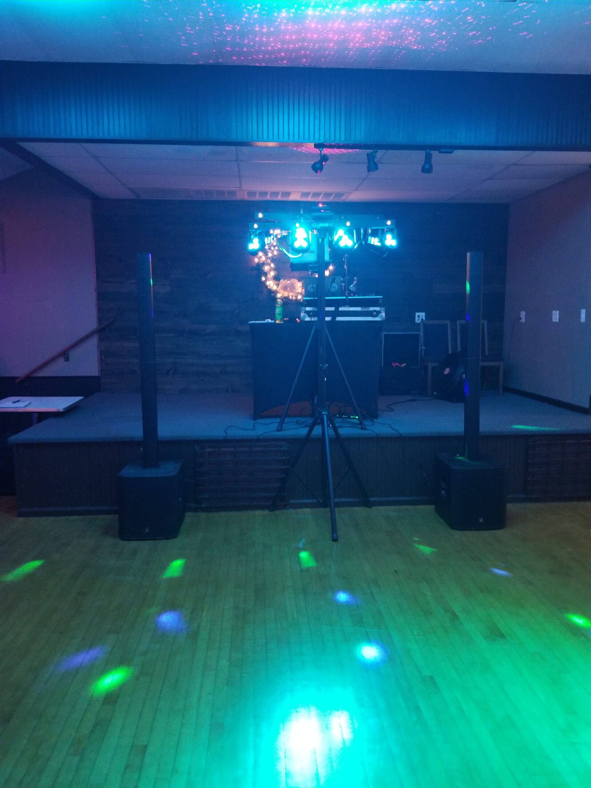 Empty dance floor with DJ setup and colorful lights.