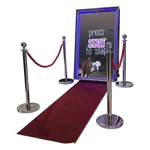 Red carpet setup with velvet ropes and a photo booth.